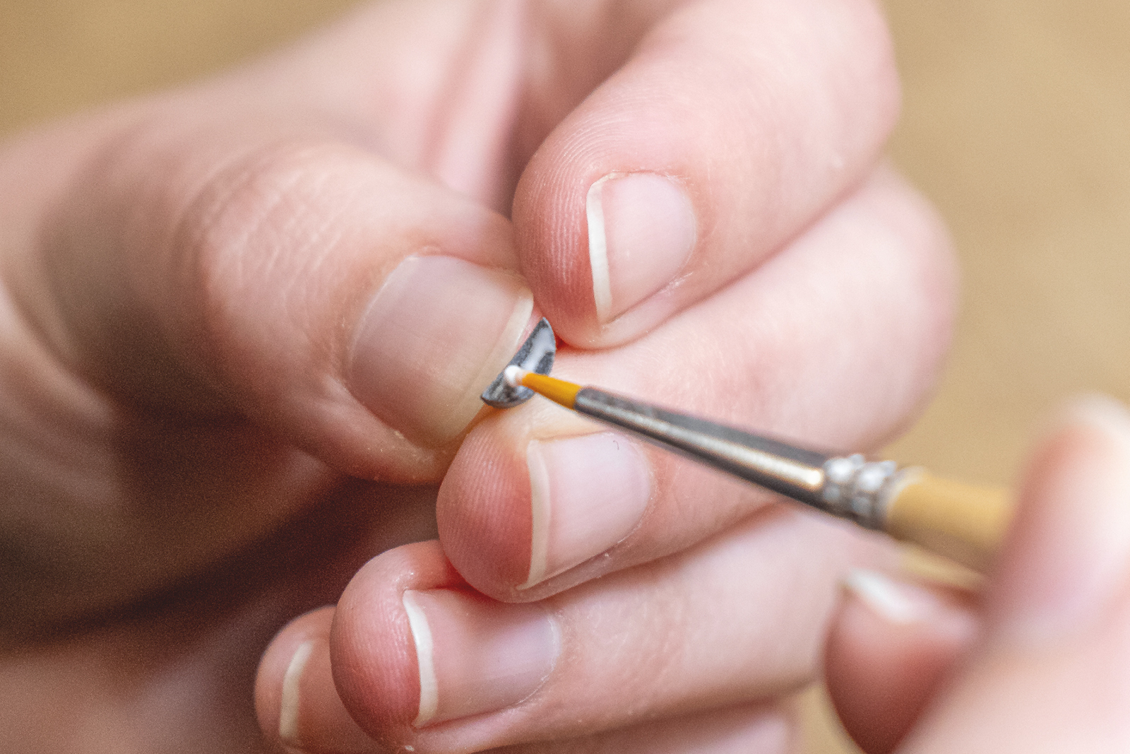 Eine schmale Leimkante wird entlang der Unterseite des Ohres gezogen.