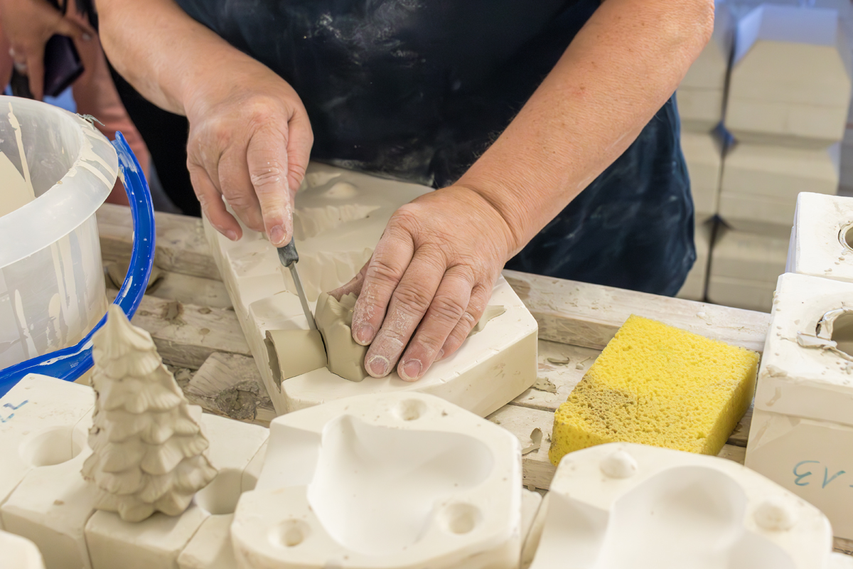 Verflüssigter Ton wird nach der Trocknung aus der Gipsform entnommen und mit einem scharfen Messer bearbeitet.