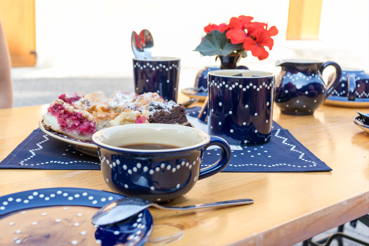 Liebevoll eingedeckt und herrlich duftend, erwarten uns gedeckte Tische im Freien.